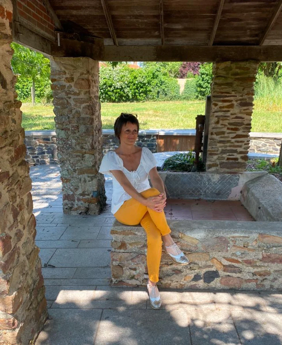 Isabelle Olivrie, assise sous un lavoir